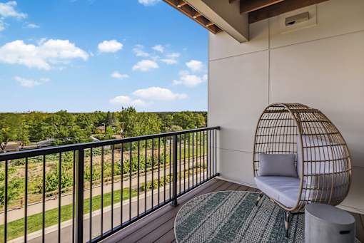 A balcony with a chair and a table.