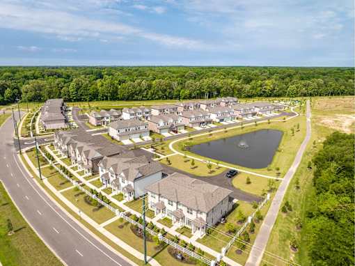 A bird's eye view of a residential area with houses and a lake.