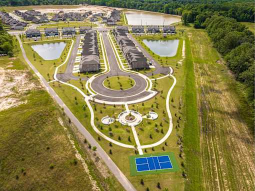A bird's eye view of a housing development with a central park area.