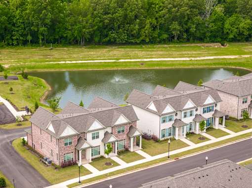 A row of houses with a pond in the front yard.