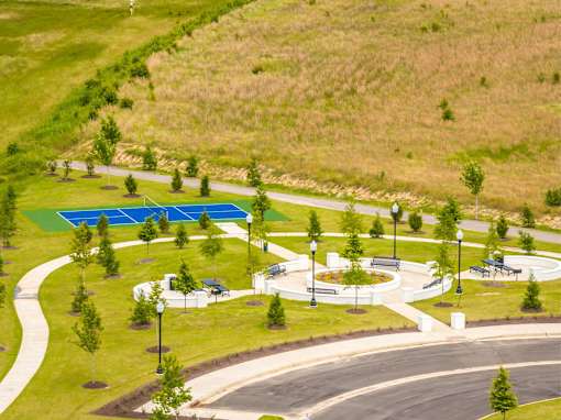 A park with a blue pool and a winding road.