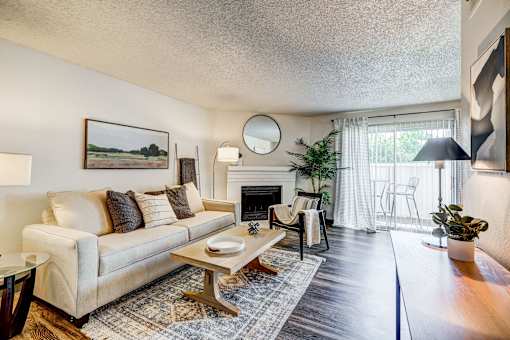 A living room with a couch, a coffee table, and a fireplace.