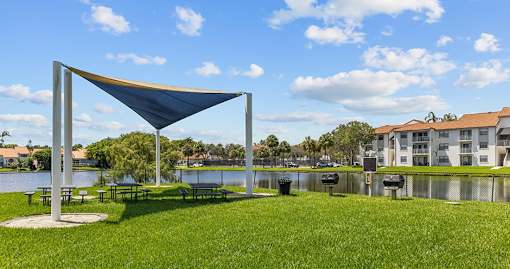A blue shade structure is in the middle of a grassy area.