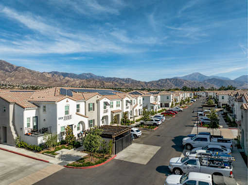 A row of houses with a mountain range in the background.