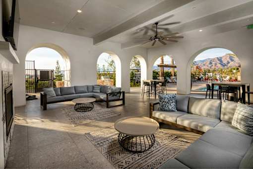 A living room with a grey couch and a rug.