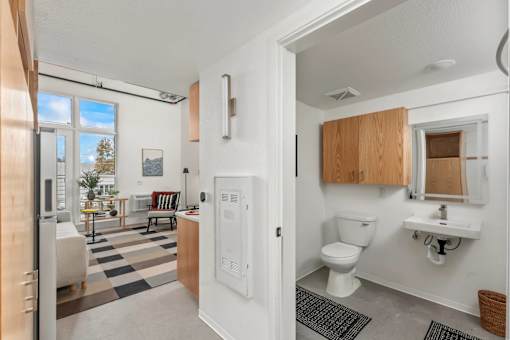 A bathroom with a toilet, sink, and mirror.
