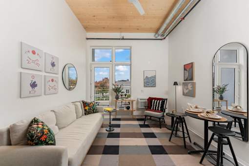 A living room with a couch, chairs, and a table.
