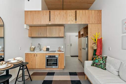A kitchen with a black and white checkered rug on the floor.