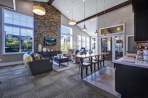 A modern open plan living and dining area with a stone wall.