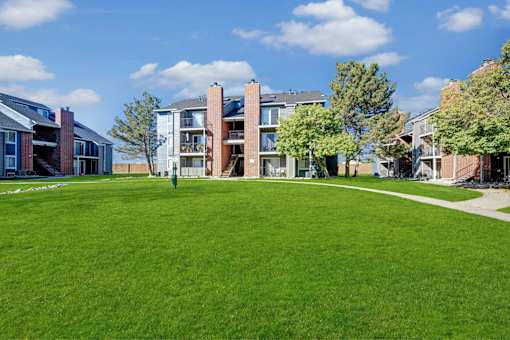A grassy area in front of apartment buildings.