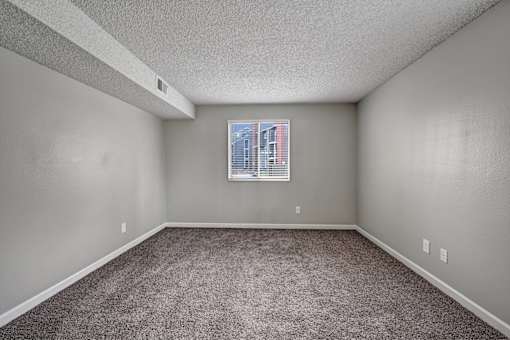 A room with a carpeted floor and a picture frame on the wall.