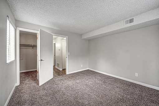 A room with a carpeted floor and a doorway leading to another room.