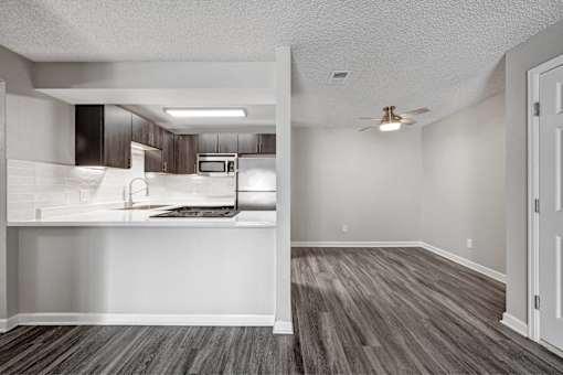 A room with a wooden floor and a ceiling fan.