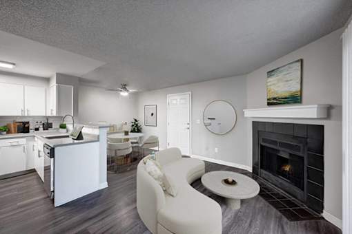 A modern living room with a fireplace and a dining area.
