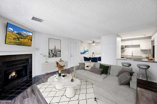 A living room with a fireplace and a painting of a mountain scene on the wall.