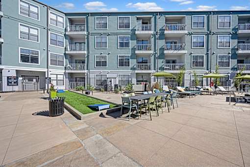 A large apartment complex with a courtyard and outdoor seating.