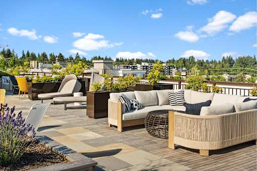 A patio with wooden furniture and a view of buildings in the distance.