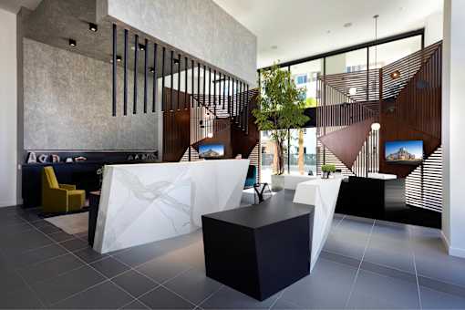 A modern reception area with a yellow chair and a white marble table