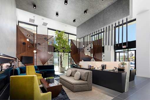 A modern living room with a yellow chair and a grey sofa