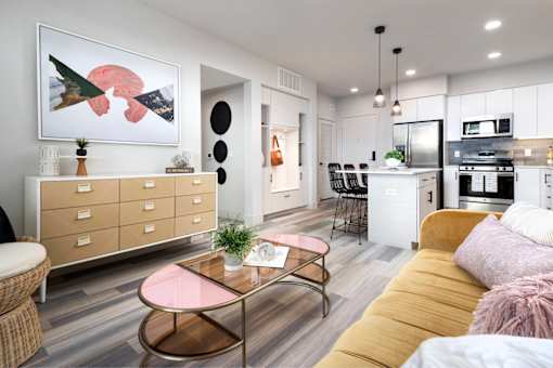 A modern living room with a pink coffee table and a yellow sofa