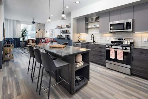 A modern kitchen with a large island and bar stools.