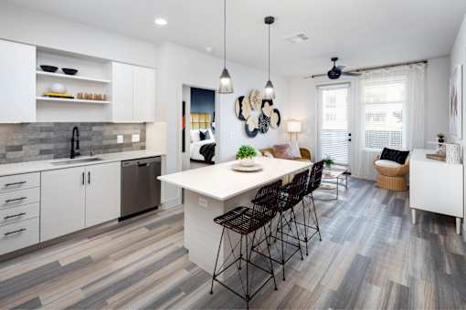 A modern kitchen with a large island and a dining area.