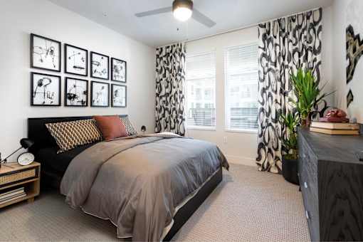 A bedroom with a large bed and a ceiling fan