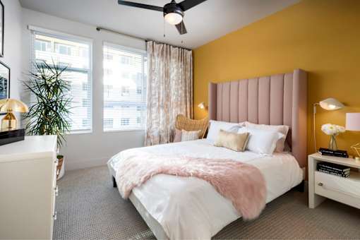 A bedroom with a white bed and a pink headboard