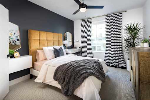 A bedroom with a large bed and a ceiling fan.