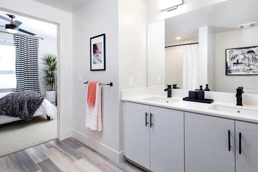A bathroom with a white vanity and a mirror above it.