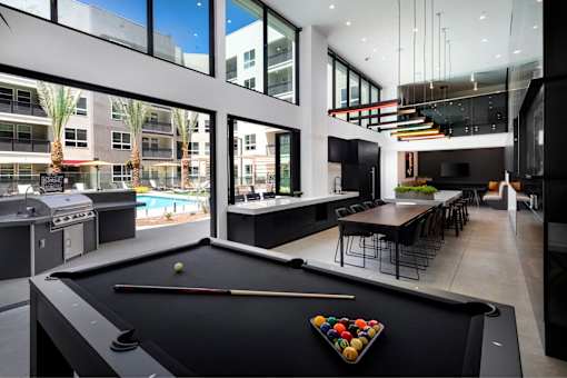 A pool table with a triangular tray of balls on it.