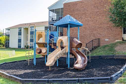 A playground with a blue and brown slide.