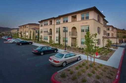 A parking lot with cars and a building in the background.