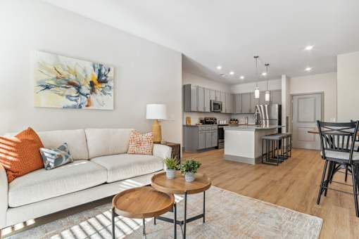 Open concept living room that leads into the kitchen with hardwood floors in our apartments for rent in Indian Land, SC.