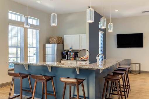 A kitchen with a bar area and stools.