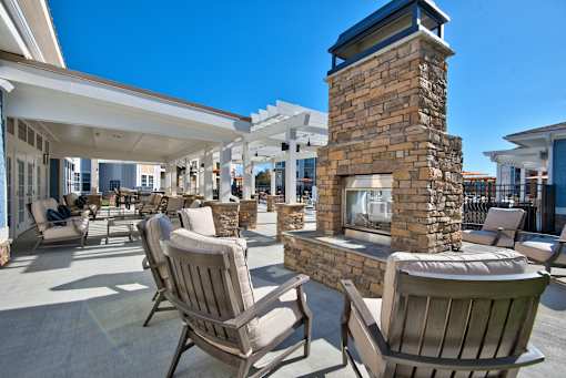 A patio with chairs and a fireplace.