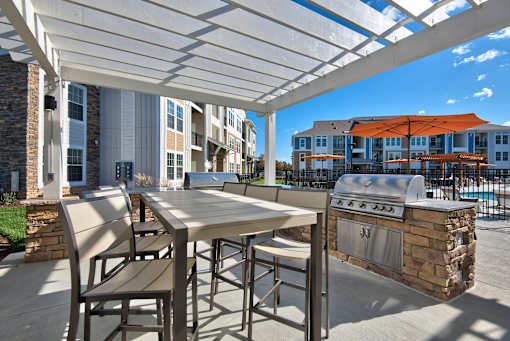 A patio with a table and chairs under a white canopy.