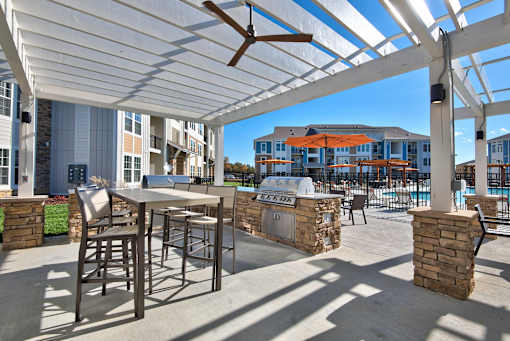 A patio with a table and chairs under a white canopy.