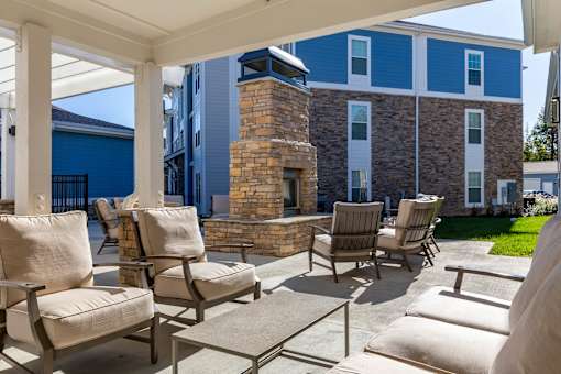 A patio with chairs and a fireplace.