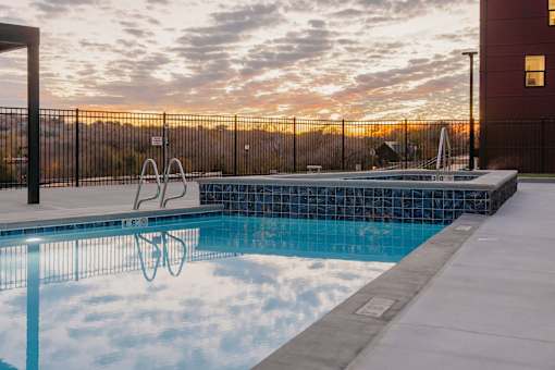 A swimming pool with a sunset in the background.