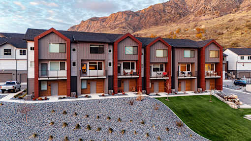 A row of modern houses with a mountain in the background.