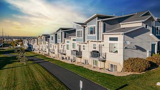 A row of modern houses with a pathway in front.