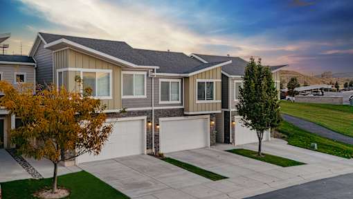 A modern house with a grey roof and a white garage door.