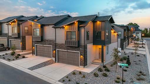 A row of modern houses with garages and driveways.