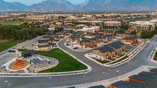 A cityscape with a large open space in the foreground and mountains in the background.