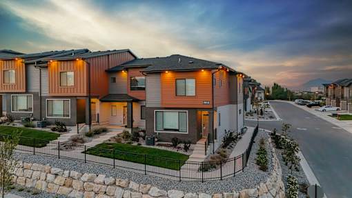 A row of modern houses with a gravel pathway in front.