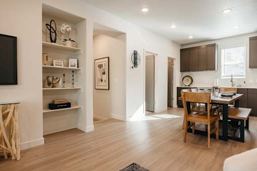 A modern living room with a dining area and a kitchen in the background.
