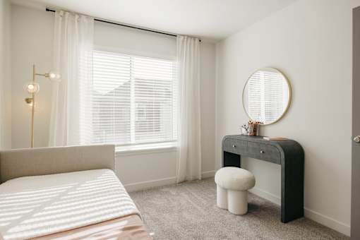 A bedroom with a bed, desk, and chair.