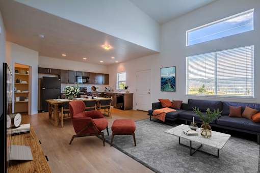 A modern living room with a kitchen area in the background.