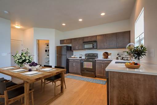 A modern kitchen with a dining table set for two.